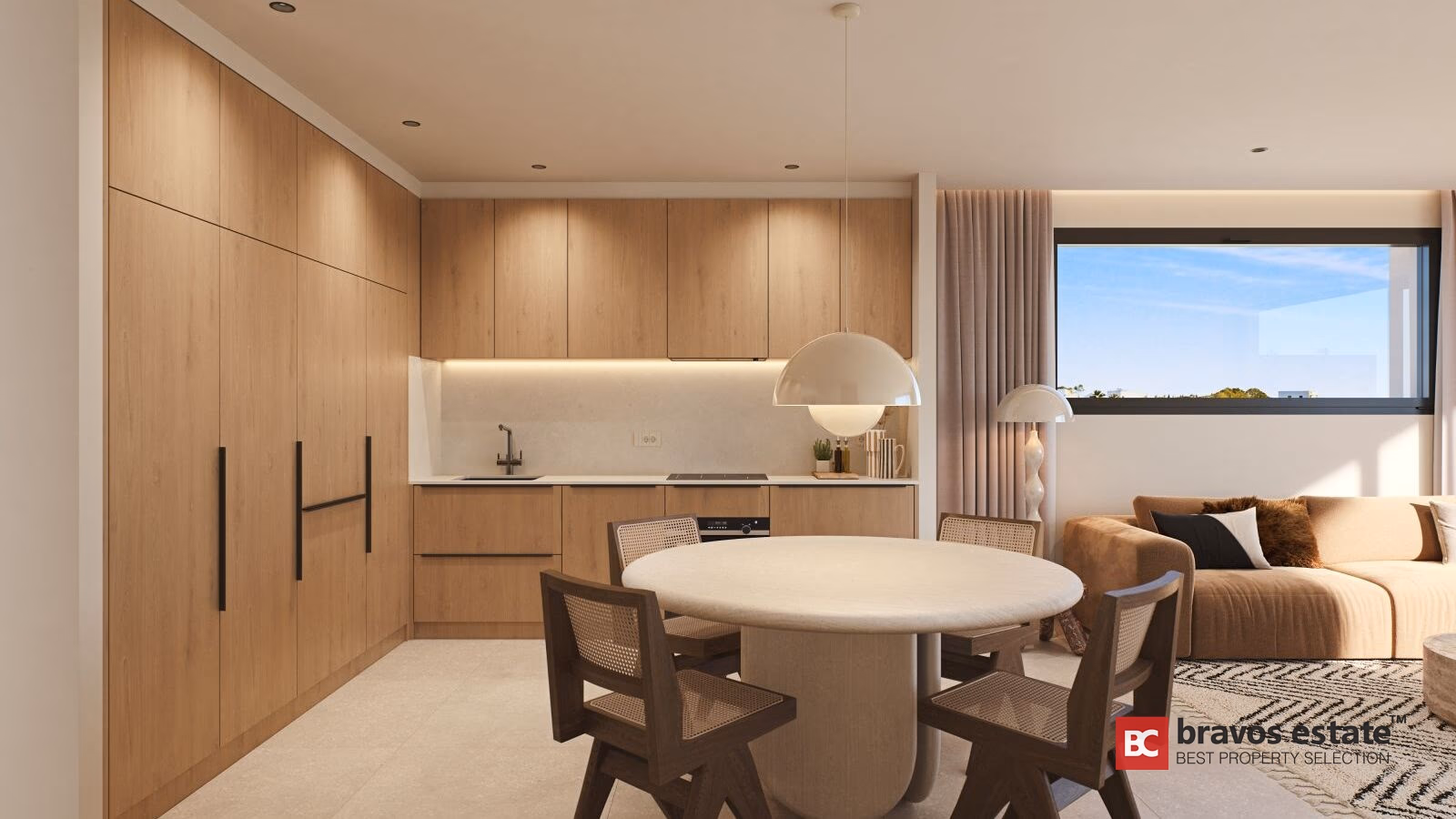 Modern kitchen with light wood cabinetry, induction hob, and round dining table with rattan chairs