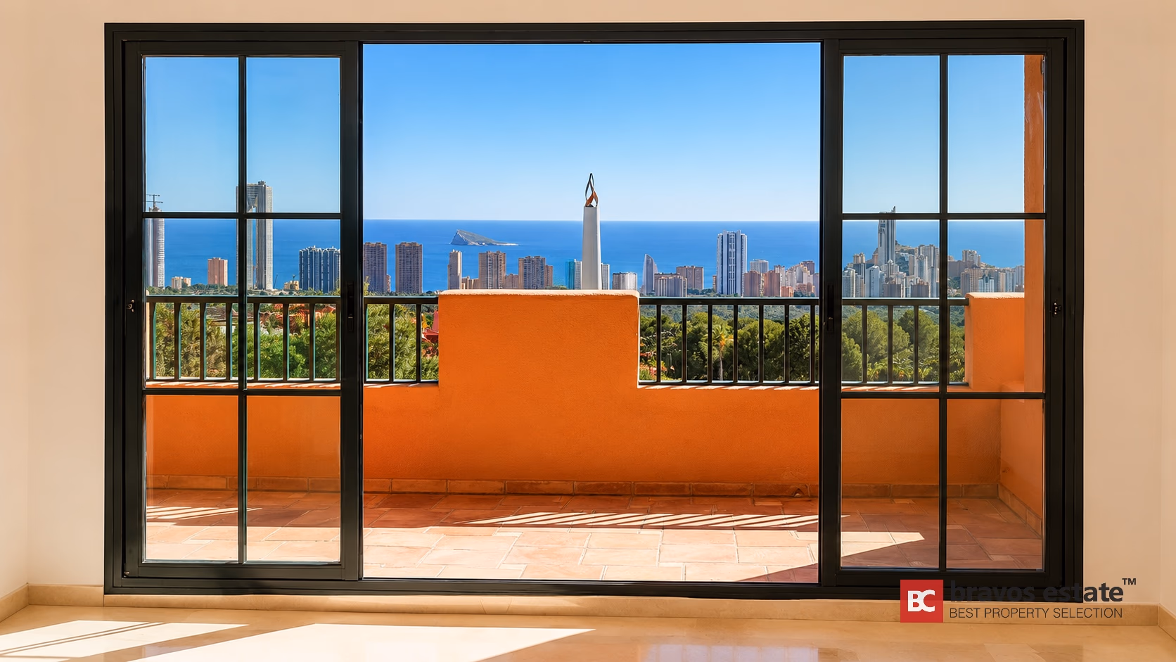 Salon vide avec portes coulissantes donnant sur terrasse avec vue mer et ville