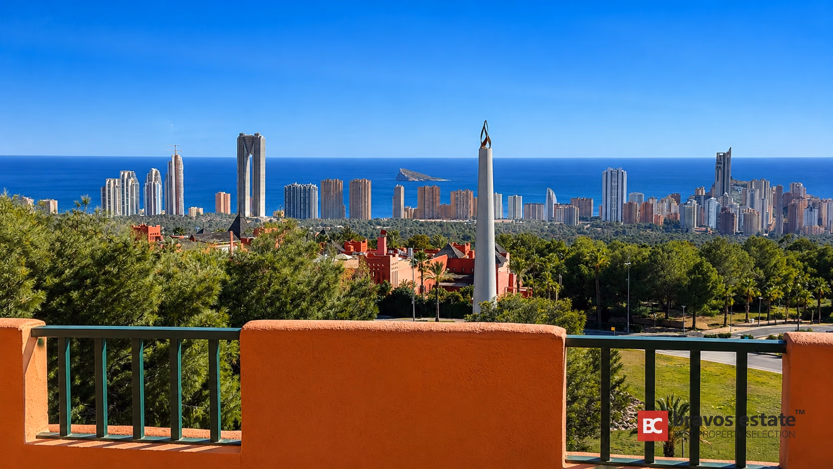 Terrasse avec portes vitrées coulissantes encadrant la skyline de Benidorm et la Méditerranée