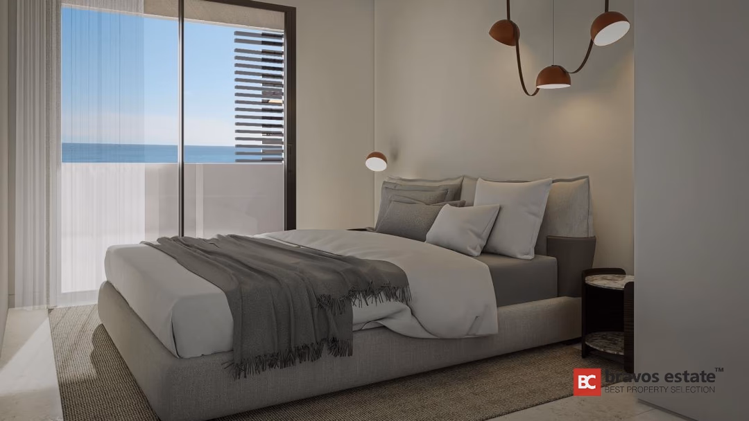Slaapkamer in Los Balcones de Calpe met grijs gestoffeerd bed, designhanglampen en balkon met zeezicht