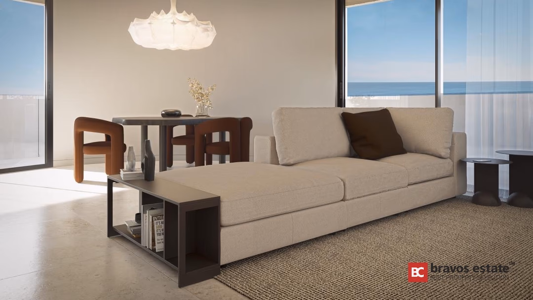 Woonkamer in Los Balcones de Calpe met gebogen muren, crèmekleurige bank, eethoek en panoramaramen met zeezicht