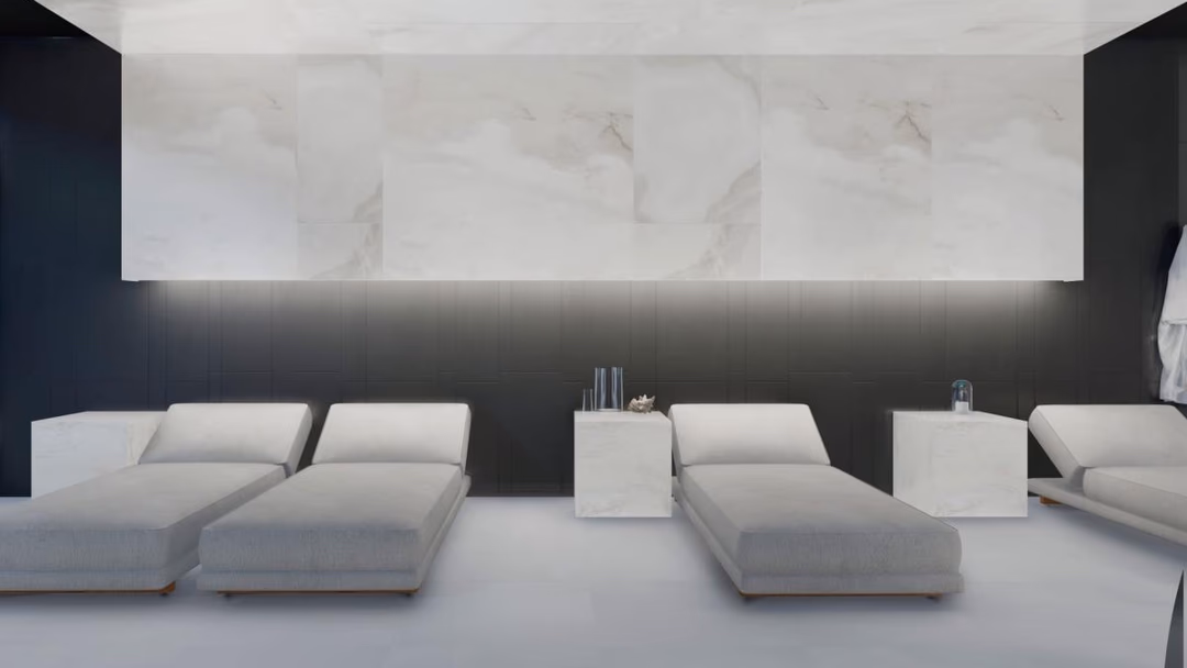 Wellnesslounge in Los Balcones de Calpe met marmeren accentmuur, ligbedden en witte minimalistische inrichting