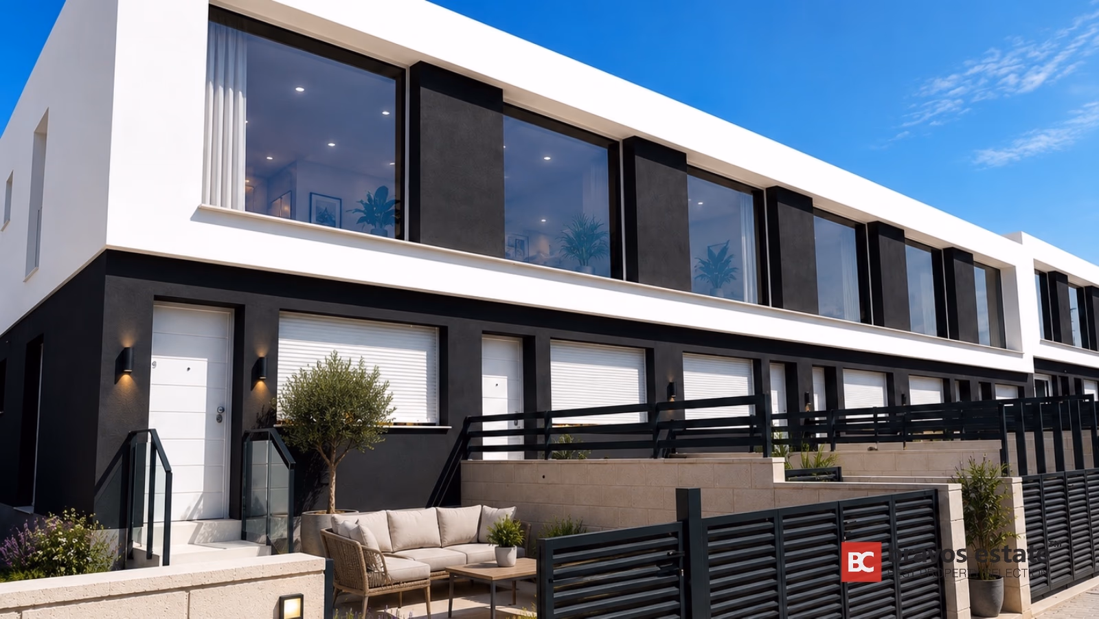 Contemporary white and charcoal townhouse with floor-to-ceiling windows and outdoor terrace seating in Gran Alacant