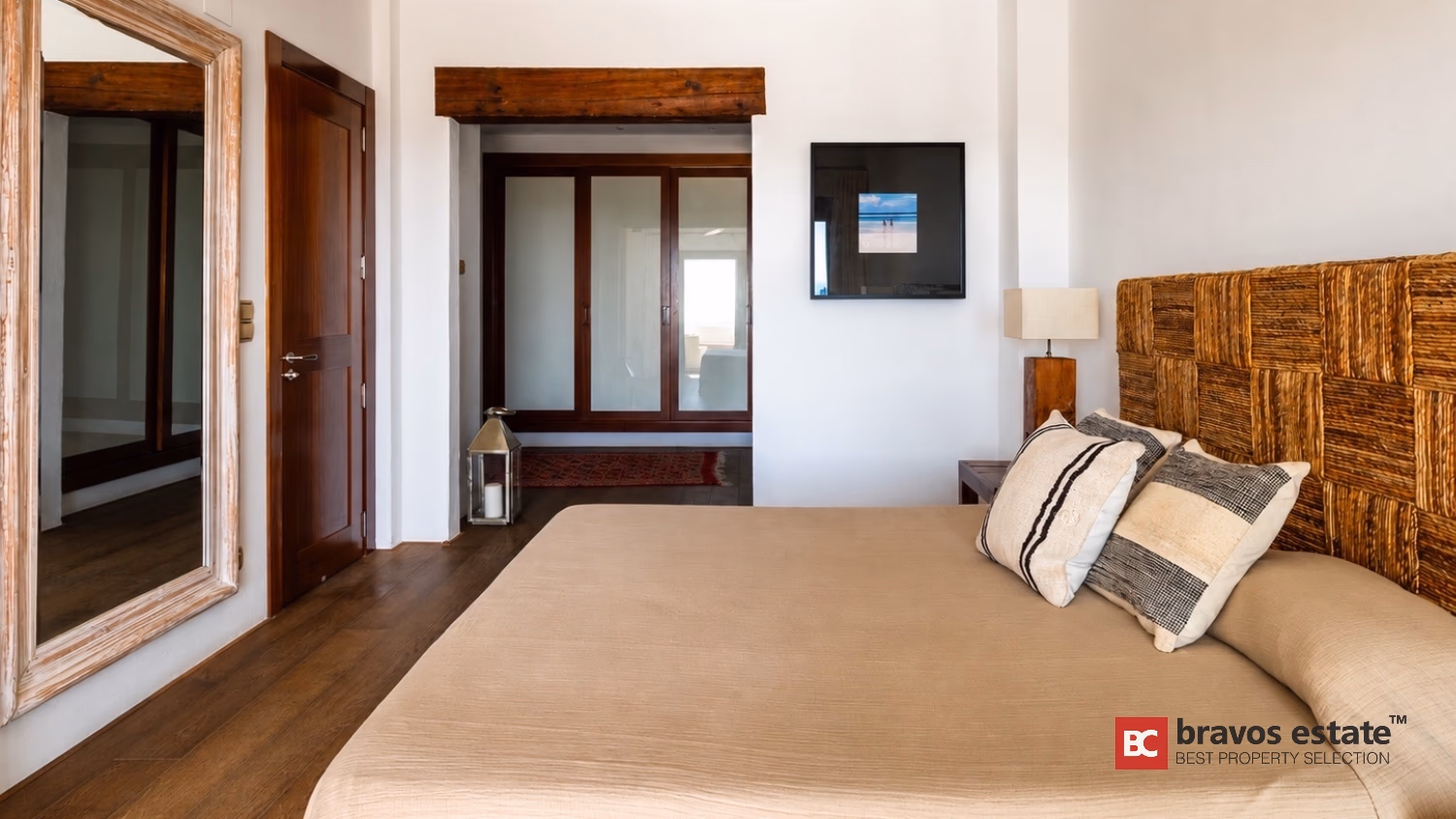Schlafzimmer mit Korbgeflecht-Kopfteil, freiliegendem Holzbalken und dekorativer Laterne in Villa Ibiza