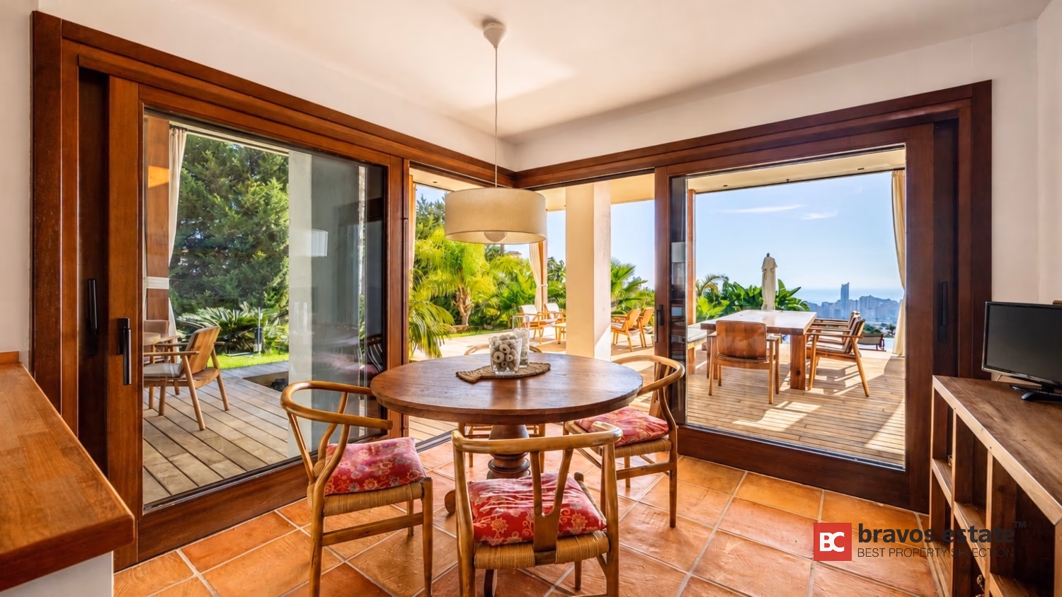 Esszimmer der Villa Ibiza mit Holzschiebetüren zur Terrasse mit Meerblick