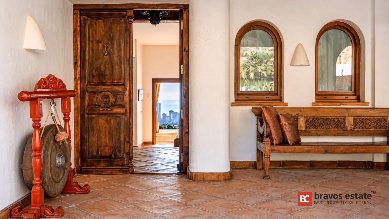 Eingangshalle der Villa Ibiza mit geschnitzter antiker Holzhauptür und gewölbten Fensternischen