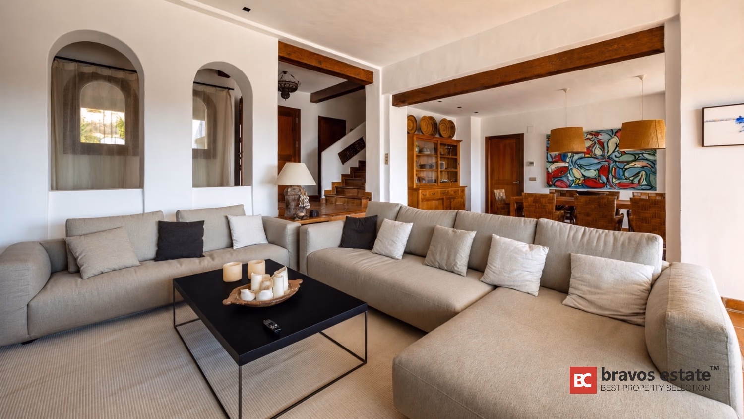 Wohnzimmer der Villa Ibiza mit Bogenfensternischen, weißen Sofas und Essbereich