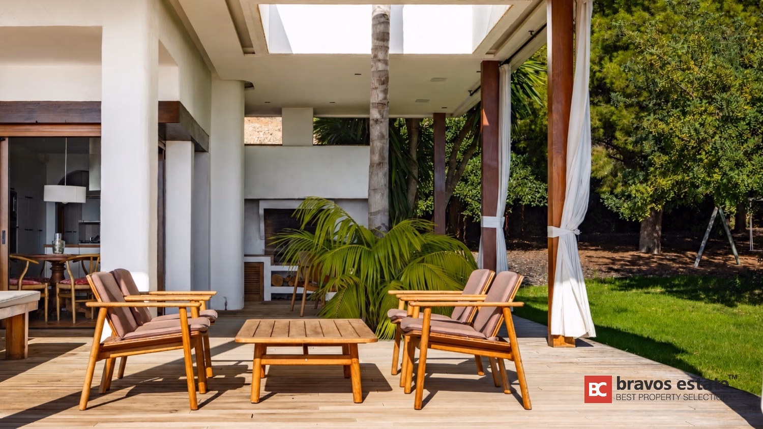 Outdoor-Loungebereich unter Holzpergola mit Palme an der Villa Ibiza