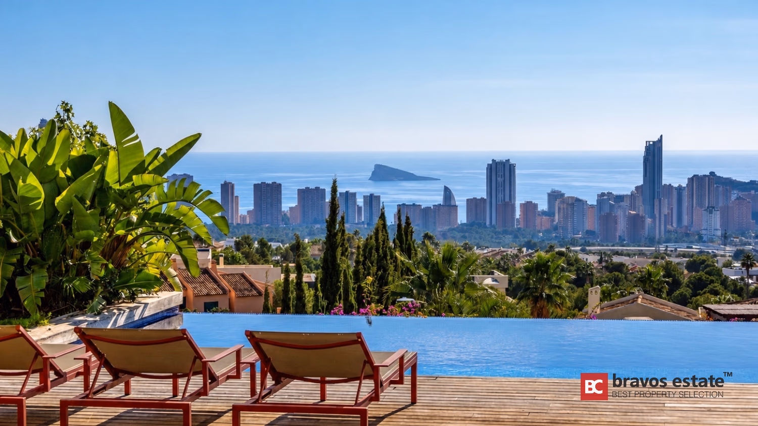 Infinity-Pool mit Liegestühlen und Palmen mit Blick auf Benidorm Skyline in Villa Ibiza