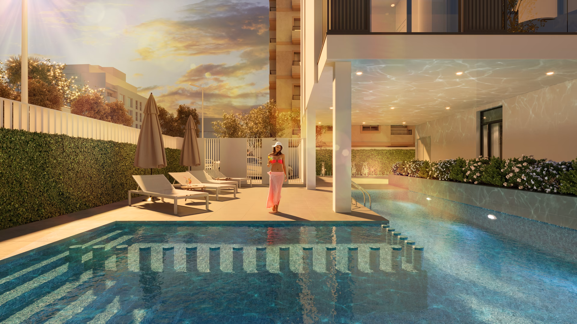 Piscina comunitaria con tumbonas, parcialmente cubierta bajo el edificio