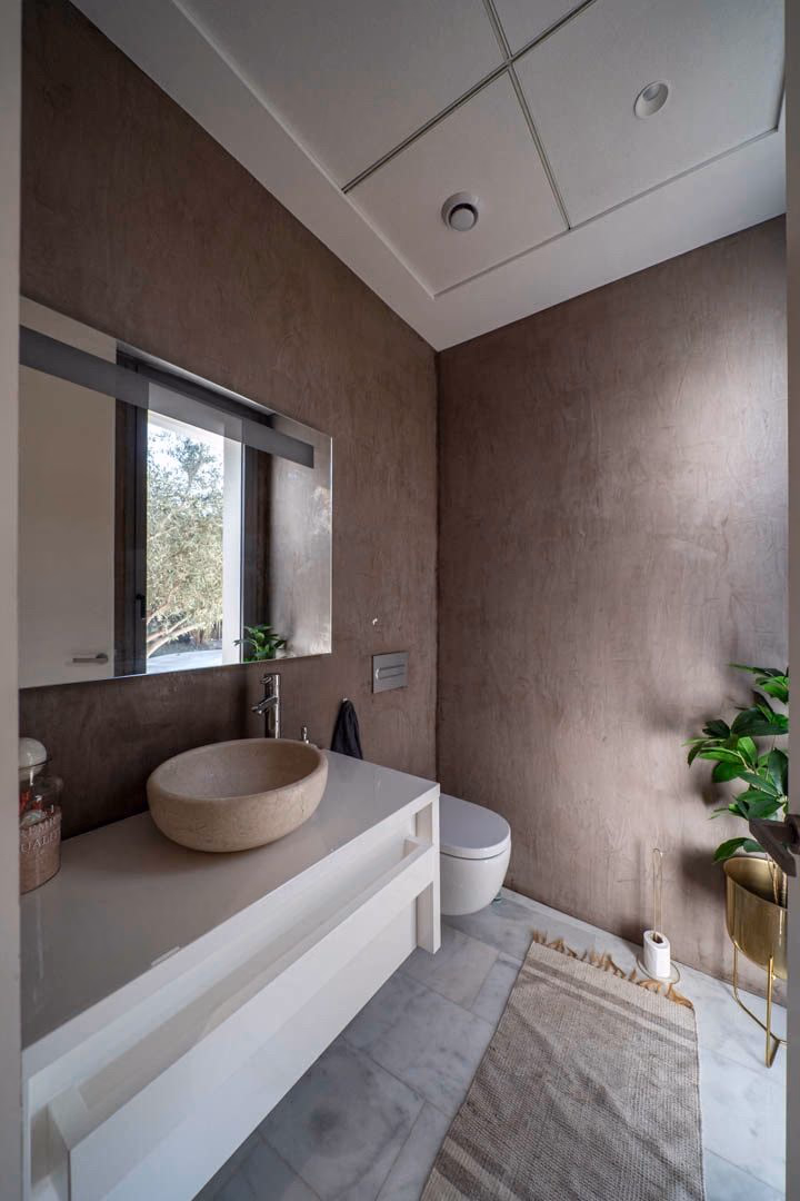 Gasten-WC met stenen wasbak en microcement-wanden