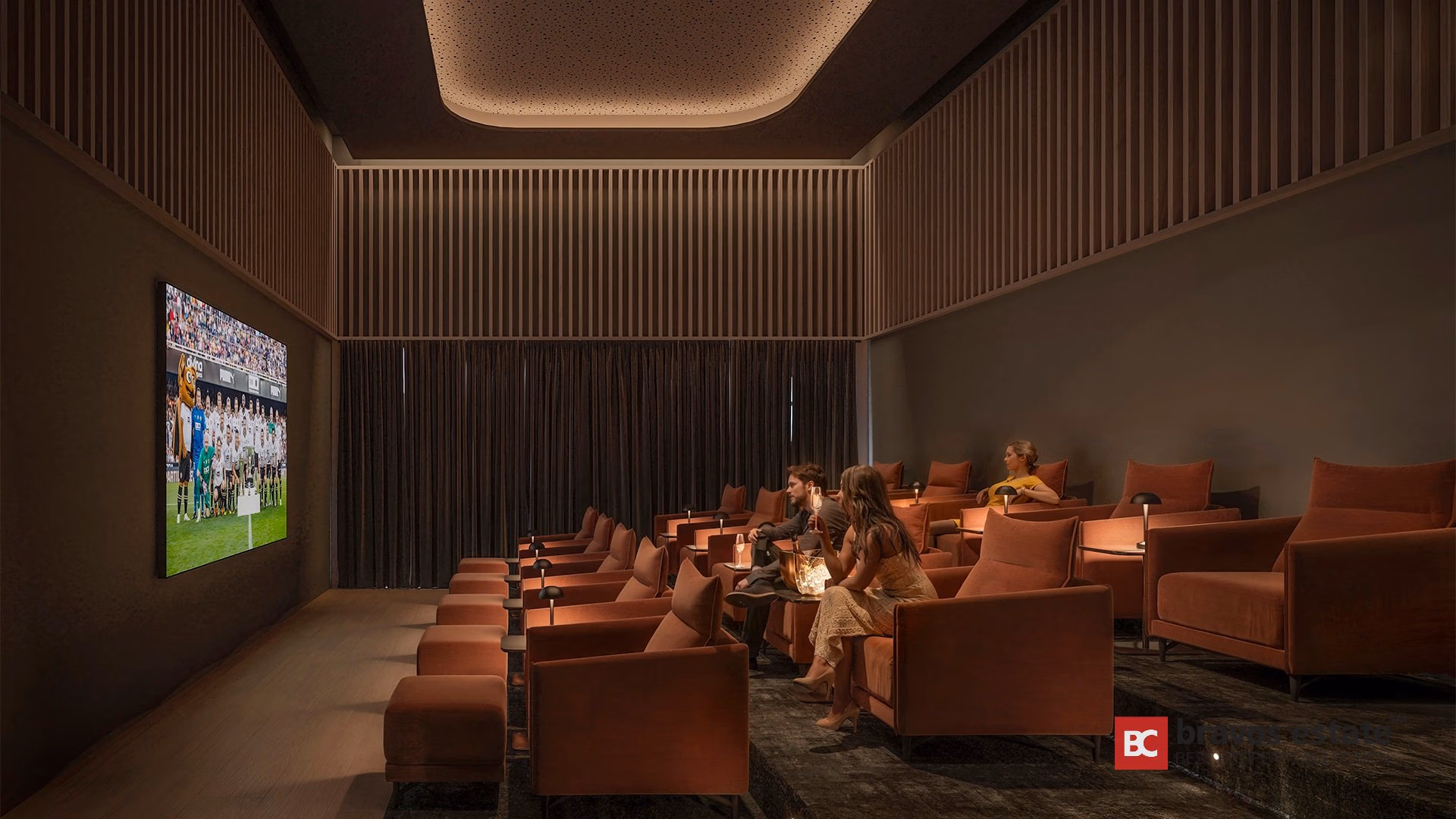 Private cinema lounge at TM Tower with terracotta velvet armchairs, vertical wood slat walls, and large screen