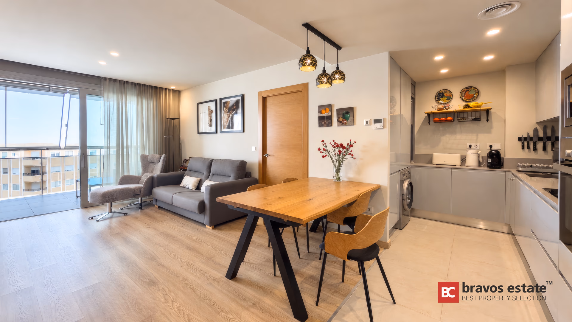 Salon z jadalnią: sofa, lampa stojąca i otwarta kuchnia wzdłuż tylnej ściany