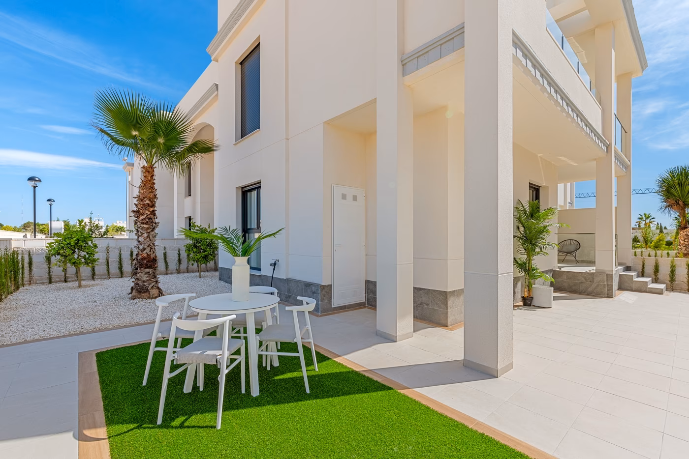 Ground-floor garden with a dining table on the lawn and the covered terrace