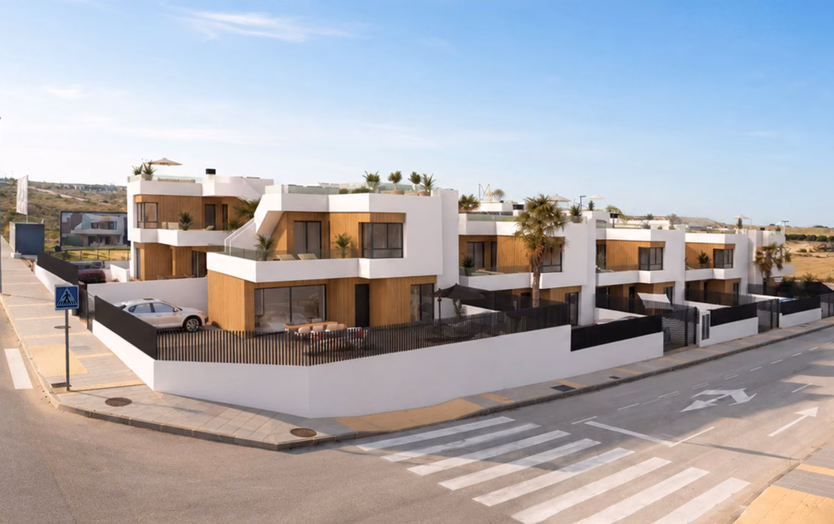 Row of white detached villas with roof terraces on a corner street