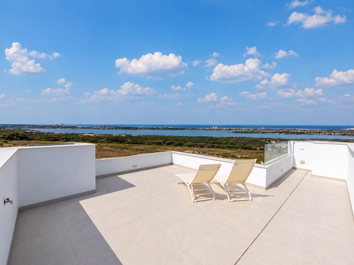 Roof terrace with two sun loungers and a glass balustrade