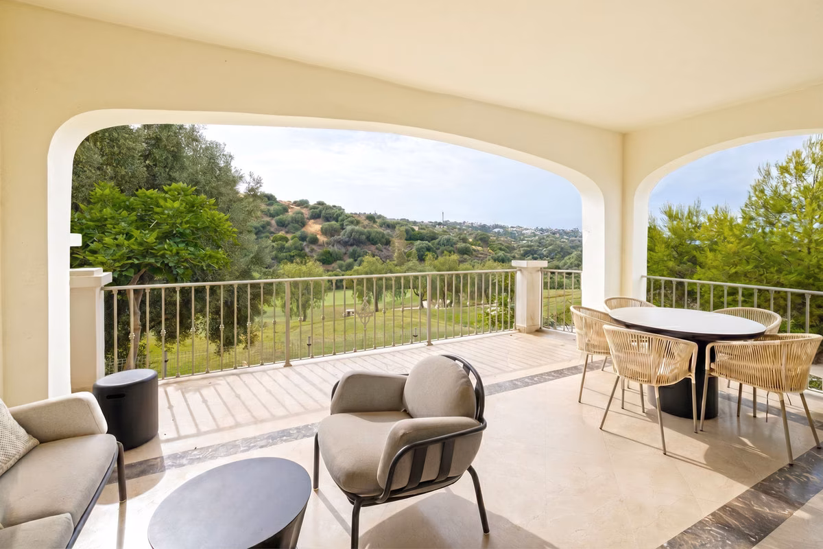 Overdekt terras met eettafel en uitzicht op de heuvels bij Altoasis, Estepona