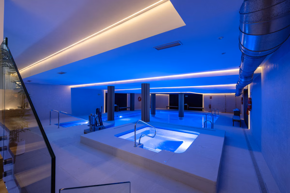 Verwarmd binnenzwembad en spa met blauwe verlichting bij Altoasis