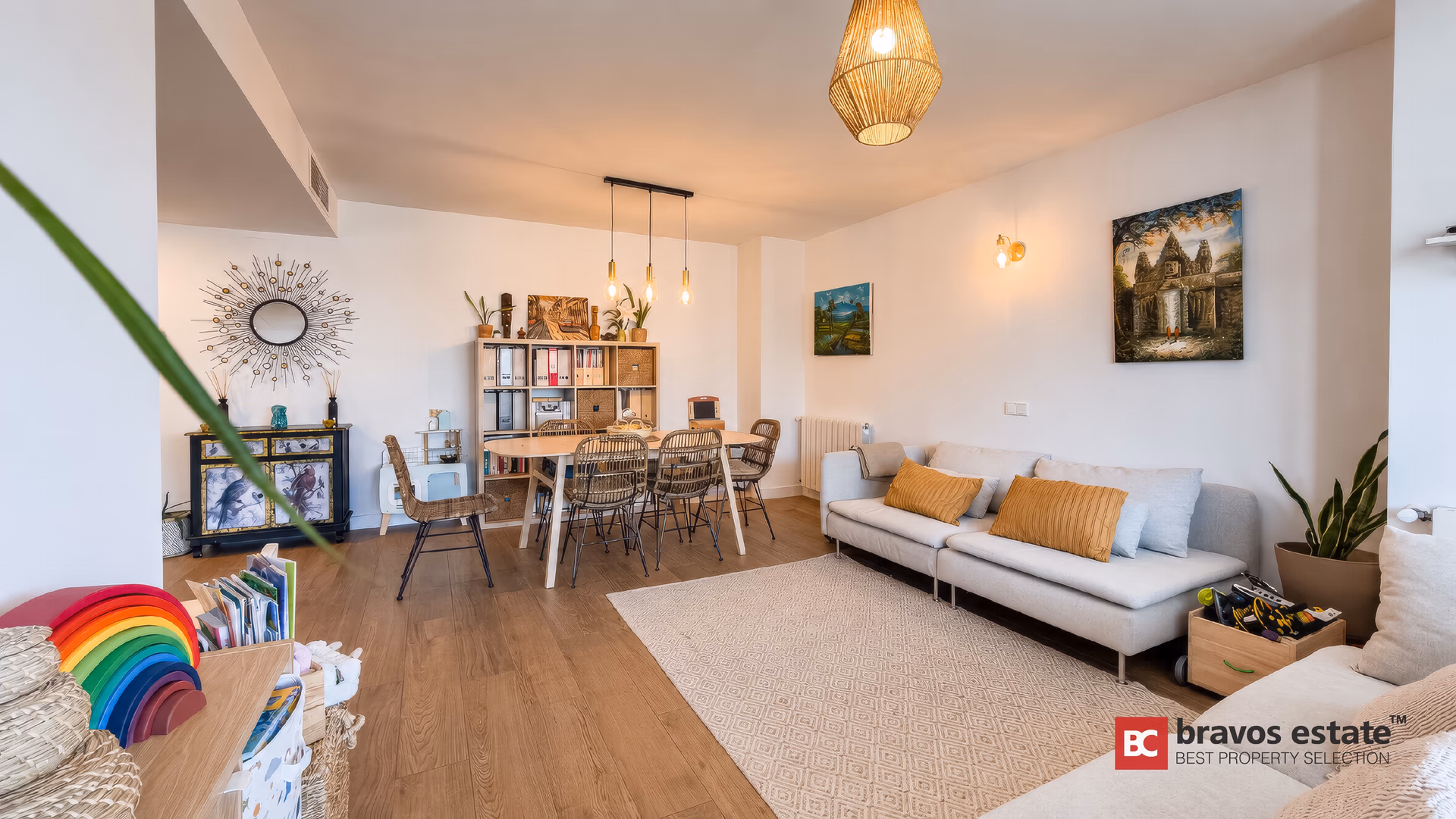 Living-dining room with an oak table, rattan chairs and the terrace beyond