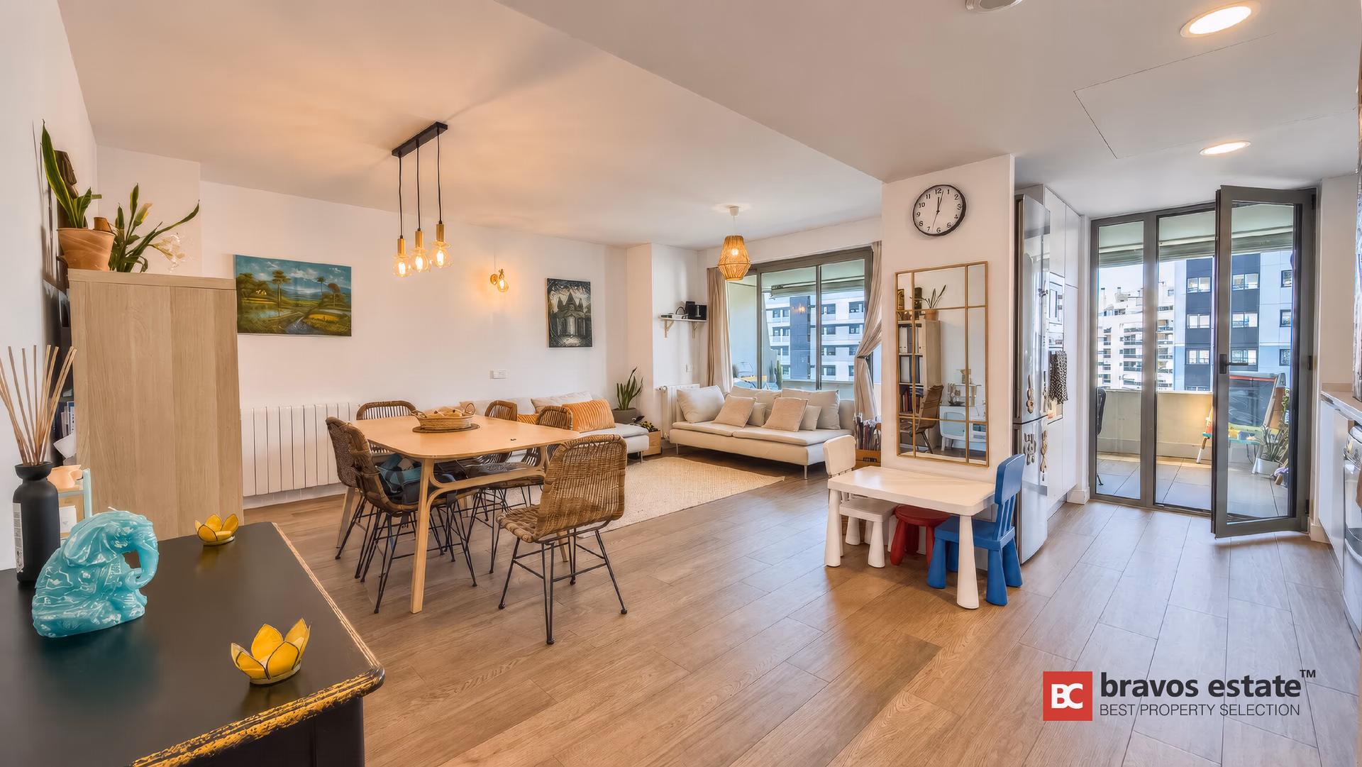 Living-dining room seen from the entrance, light wood floors and terrace doors
