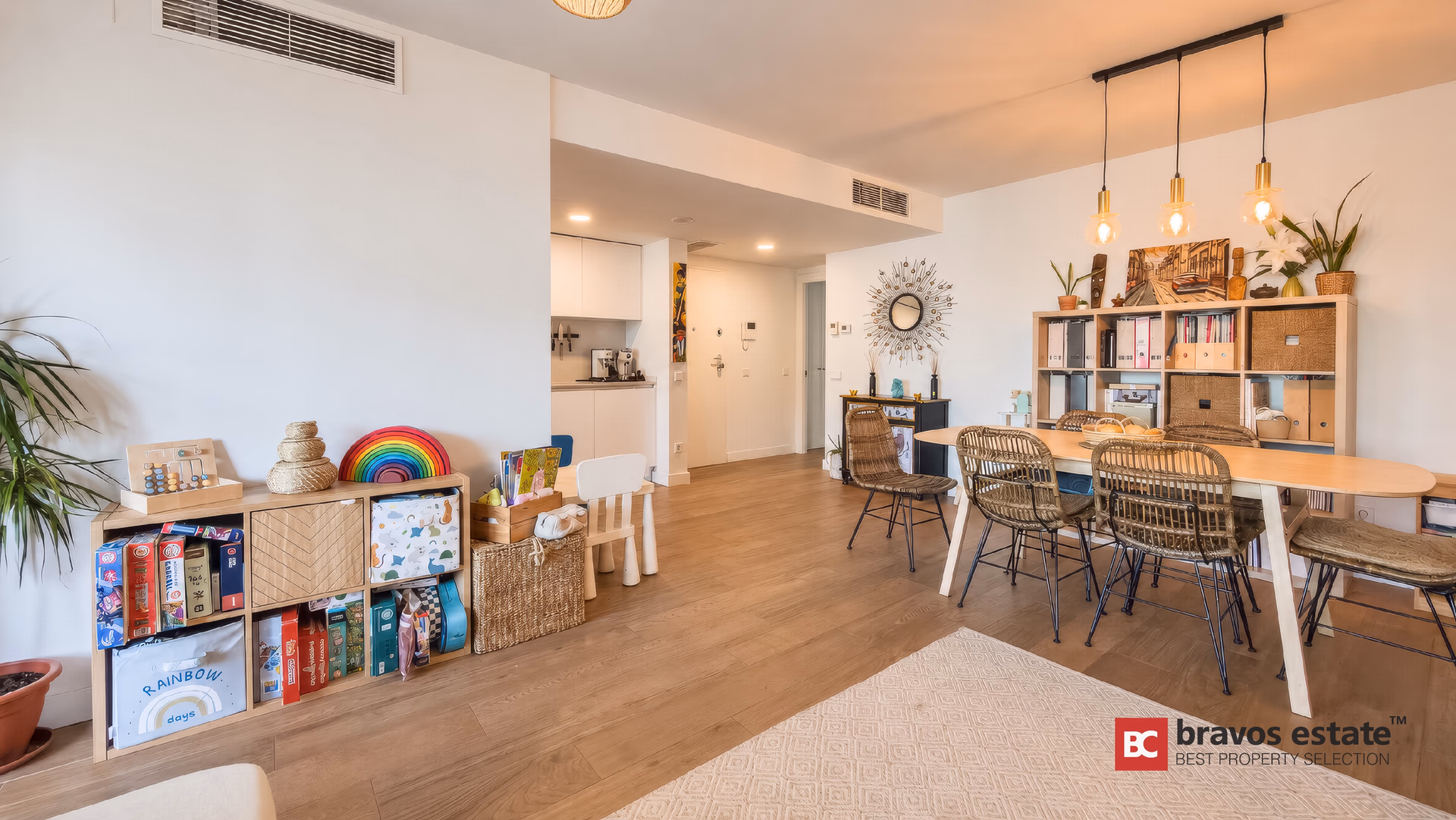 Dining table with rattan chairs and the open kitchen in the background