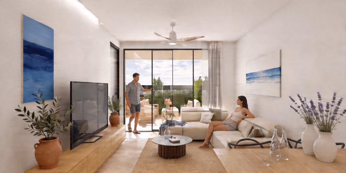 Séjour avec canapé d’angle, ventilateur de plafond et porte vitrée sur la terrasse
