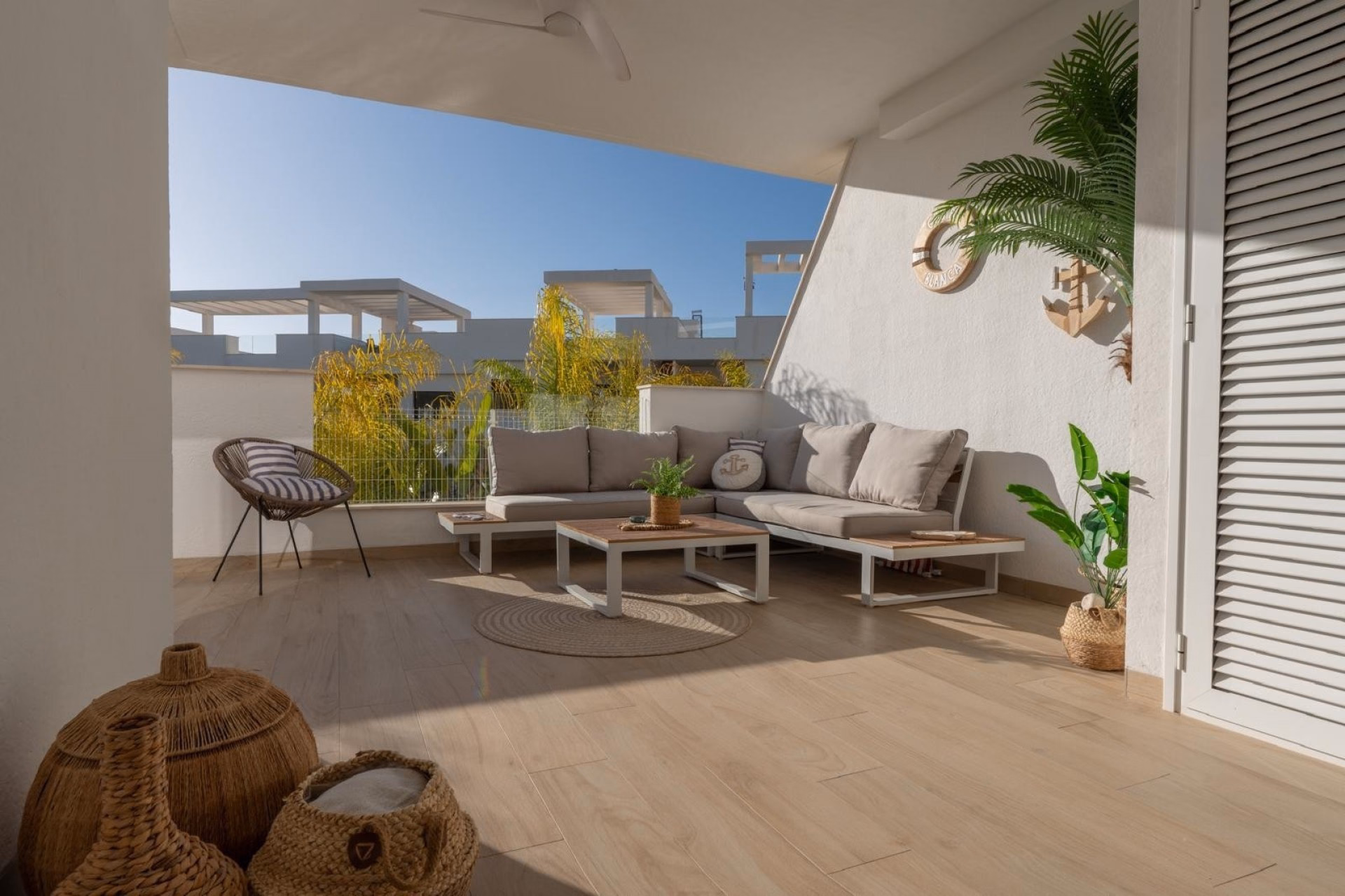 Terrace with an outdoor lounge set, plants and a parasol next to the living room
