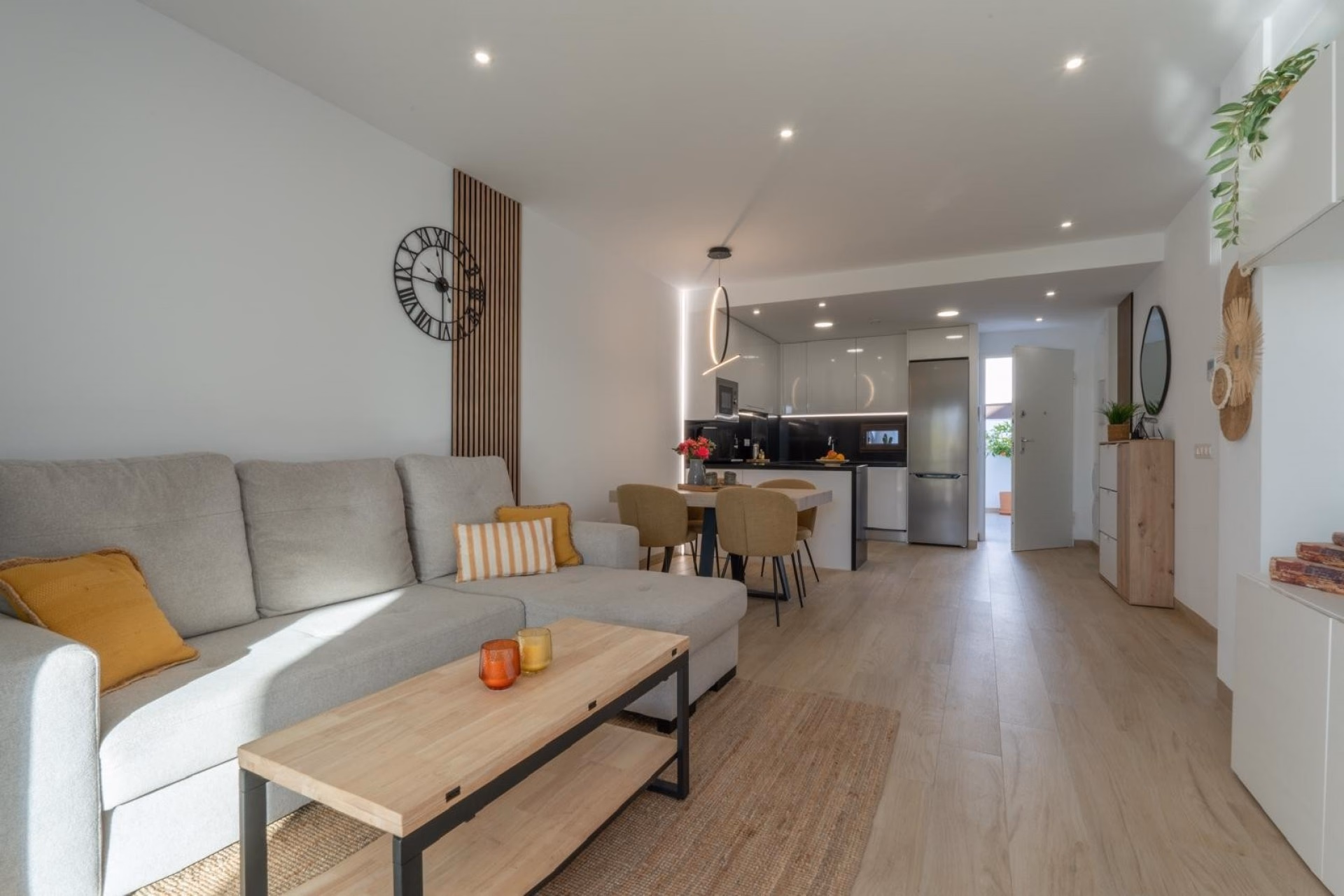 Living room with a corner sofa and the kitchen and dining area behind