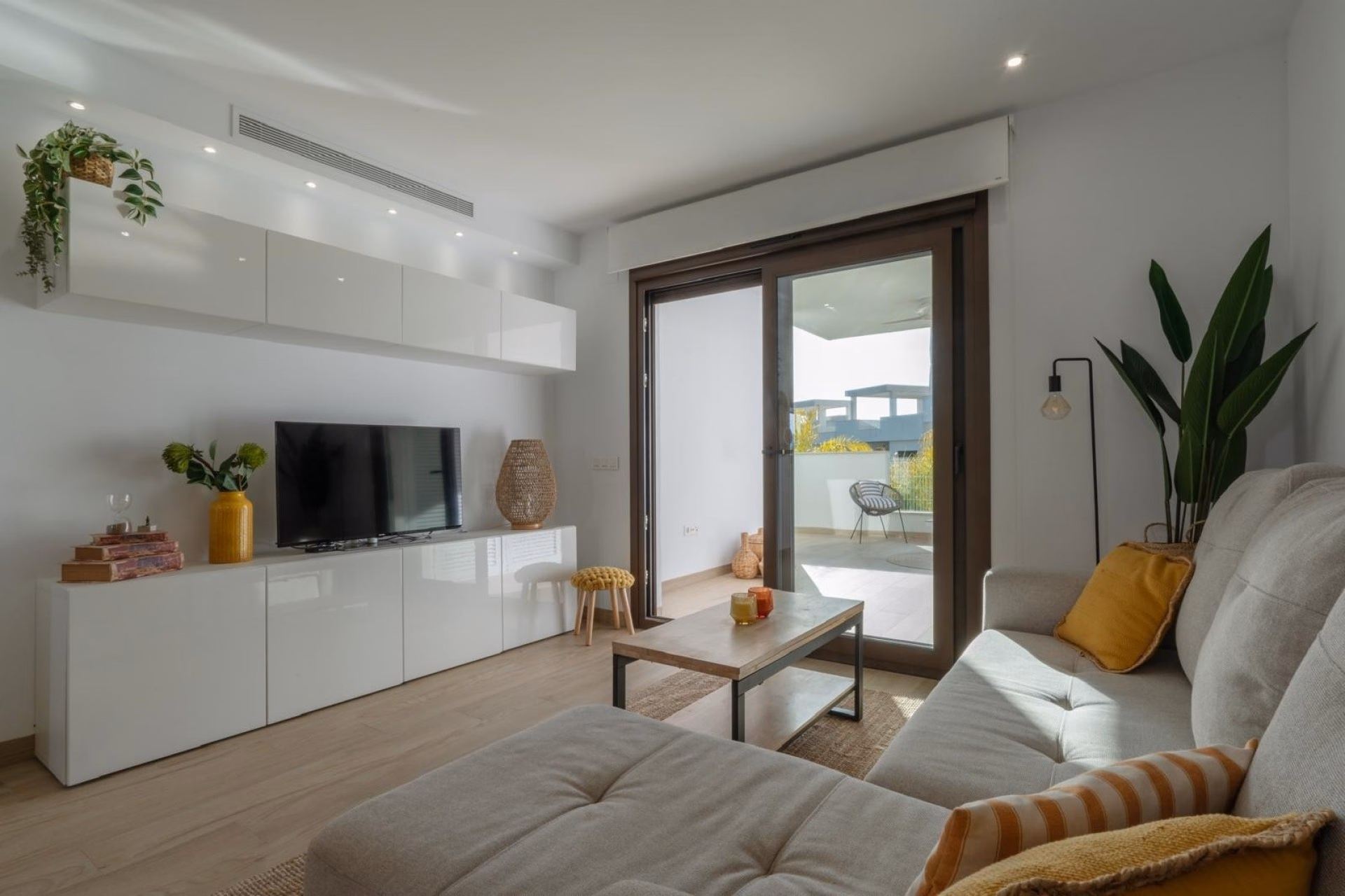 Living room with TV wall and glazed doors to the terrace