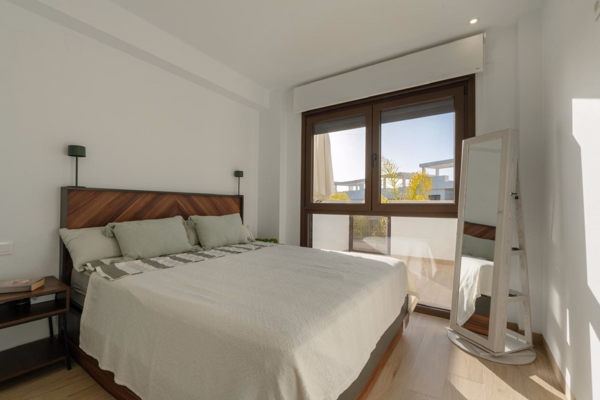 Main bedroom with a double bed, wooden headboard and window