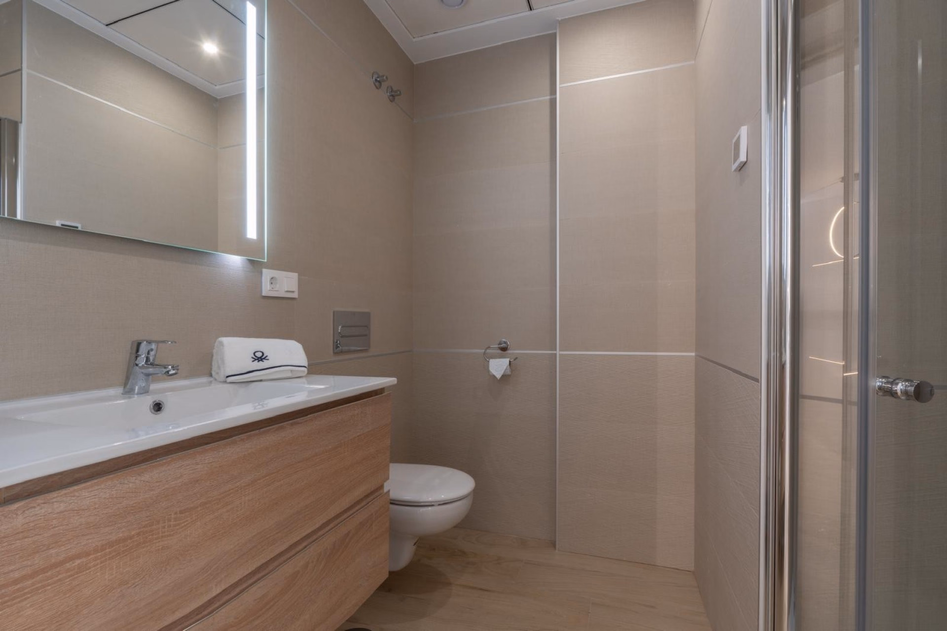 Bathroom with a wooden vanity unit and walk-in shower