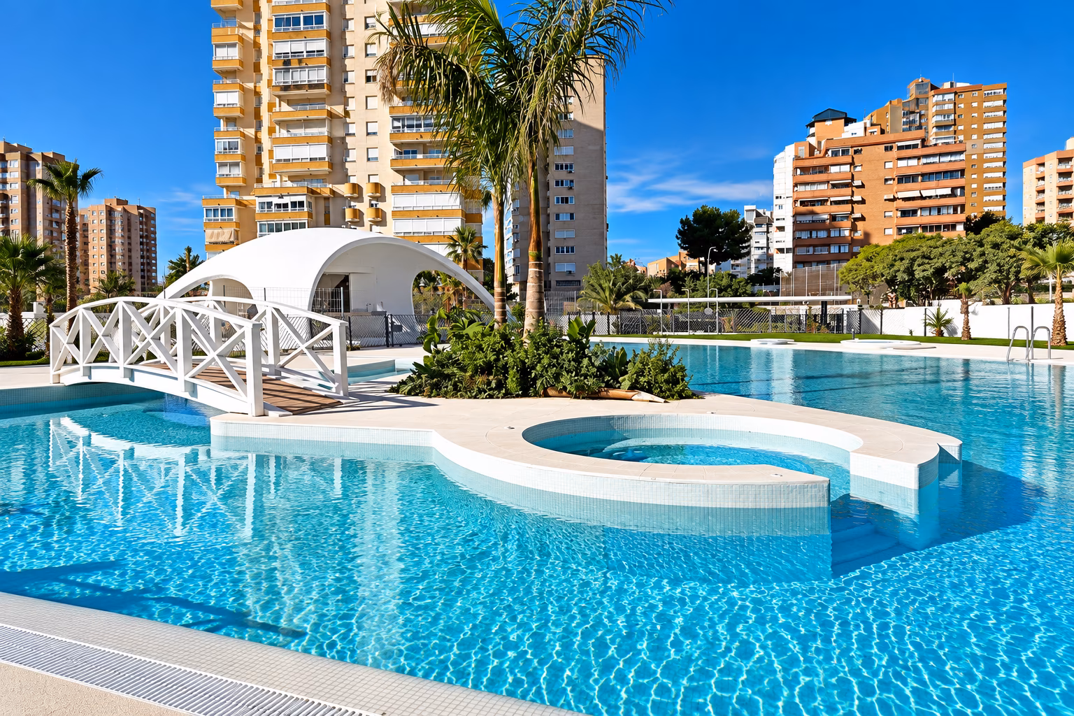 Isla en la piscina con jacuzzi redondo y pasarela