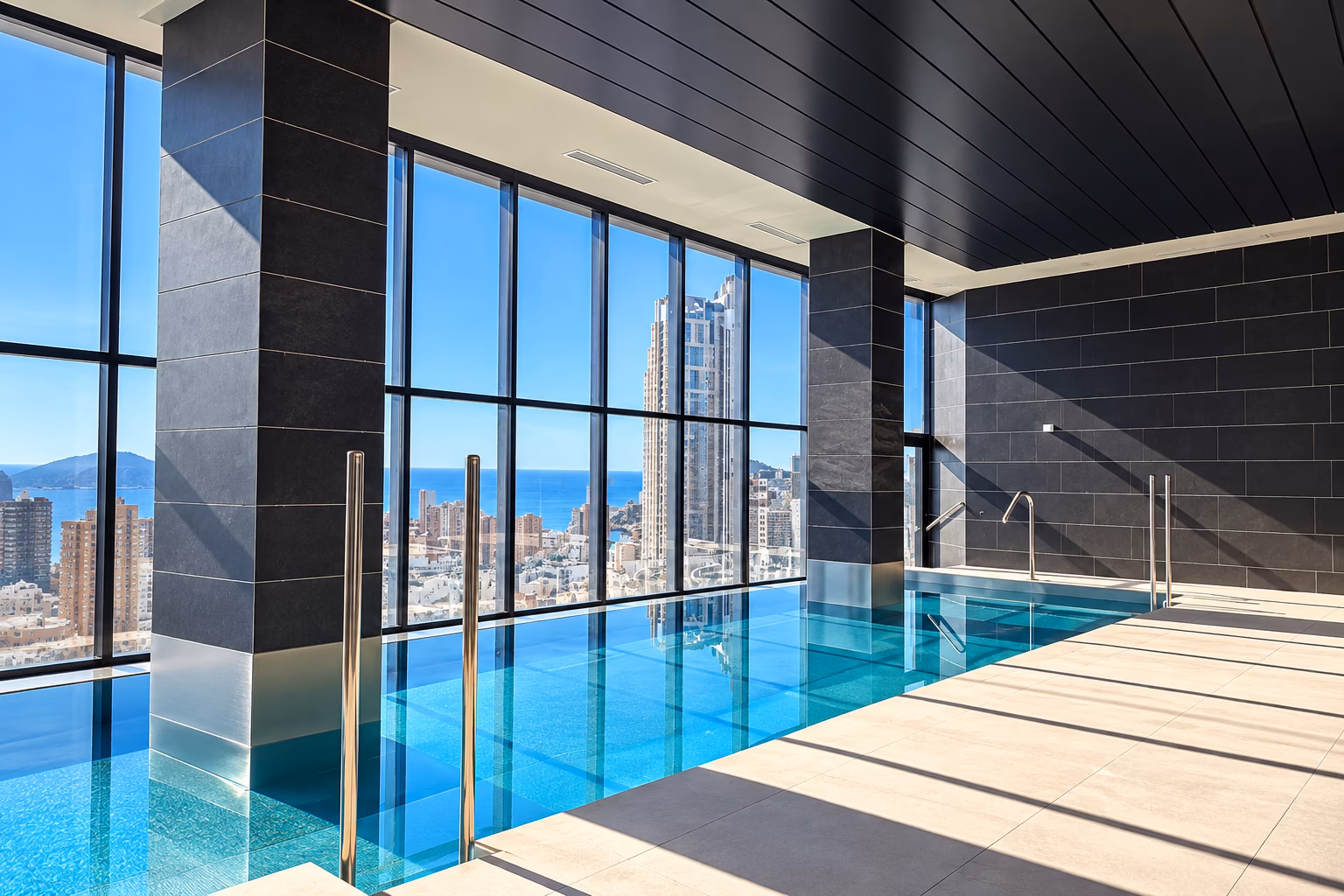 Piscina interior con cristaleras de suelo a techo sobre Benidorm