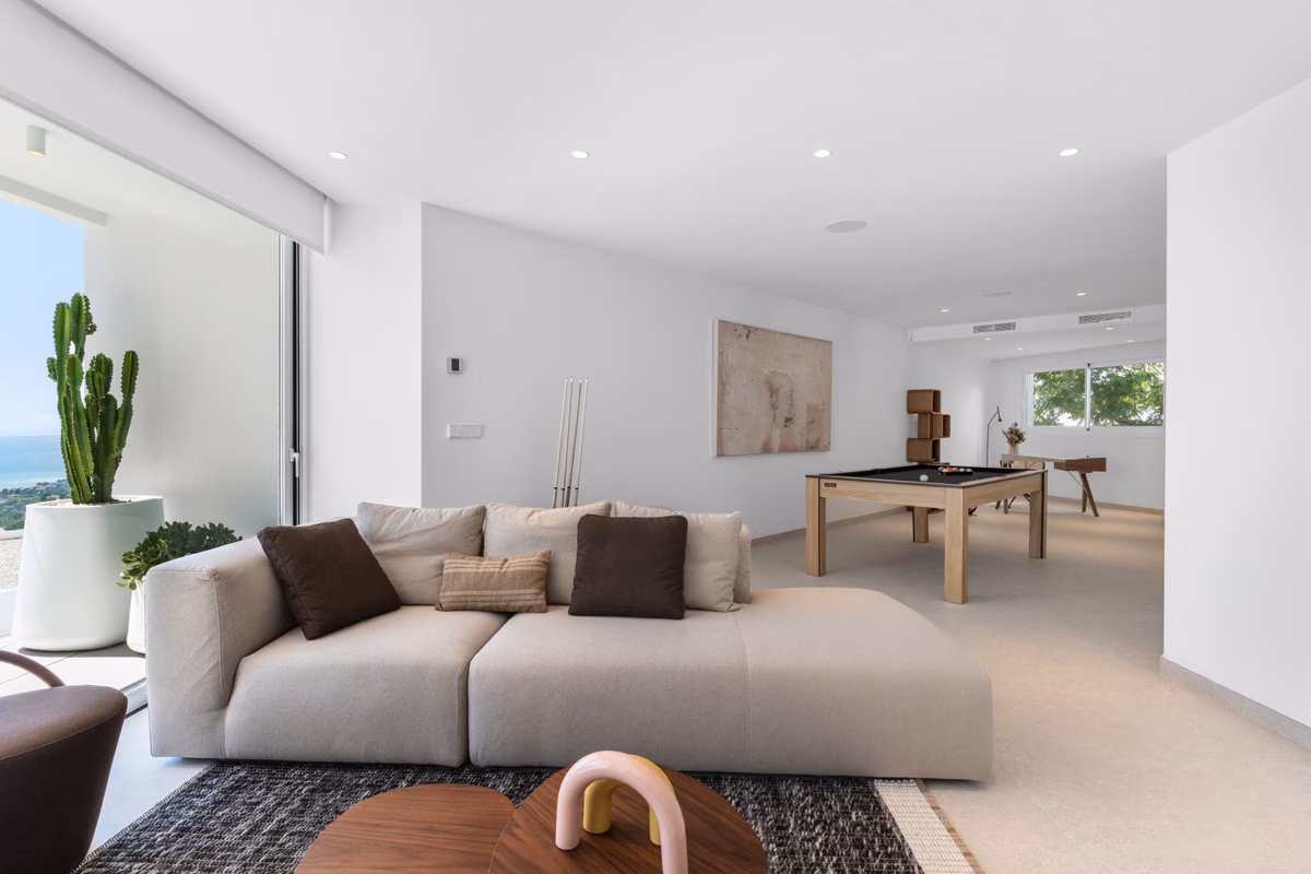 Zona de ocio con sofá y mesa de billar