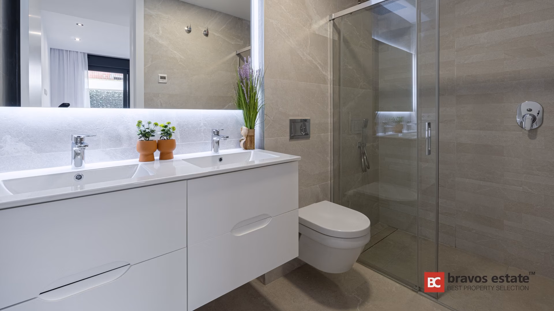 Salle de bains avec double vasque et douche à l’italienne dans un appartement témoin de Camporrosso