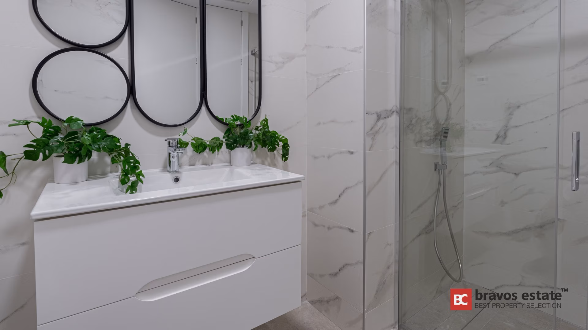 Salle de bains avec miroirs ronds et paroi de douche vitrée à Camporrosso