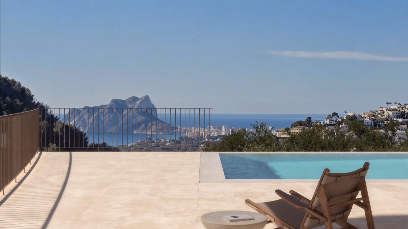 Pool deck with a lounger and the infinity pool, looking out to the sea and the Peñón de Ifach