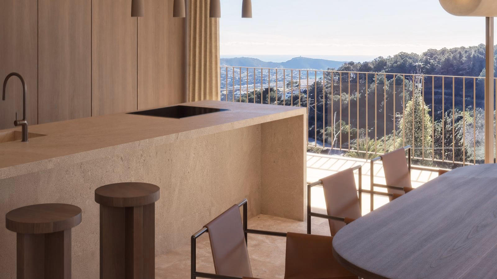 Kitchen island and dining table by an open terrace with views over the hills to the sea