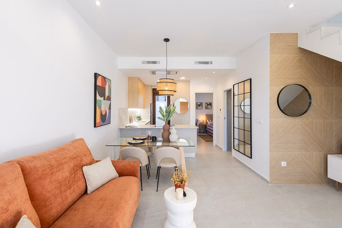 Living room with a terracotta sofa, open to the dining area and kitchen