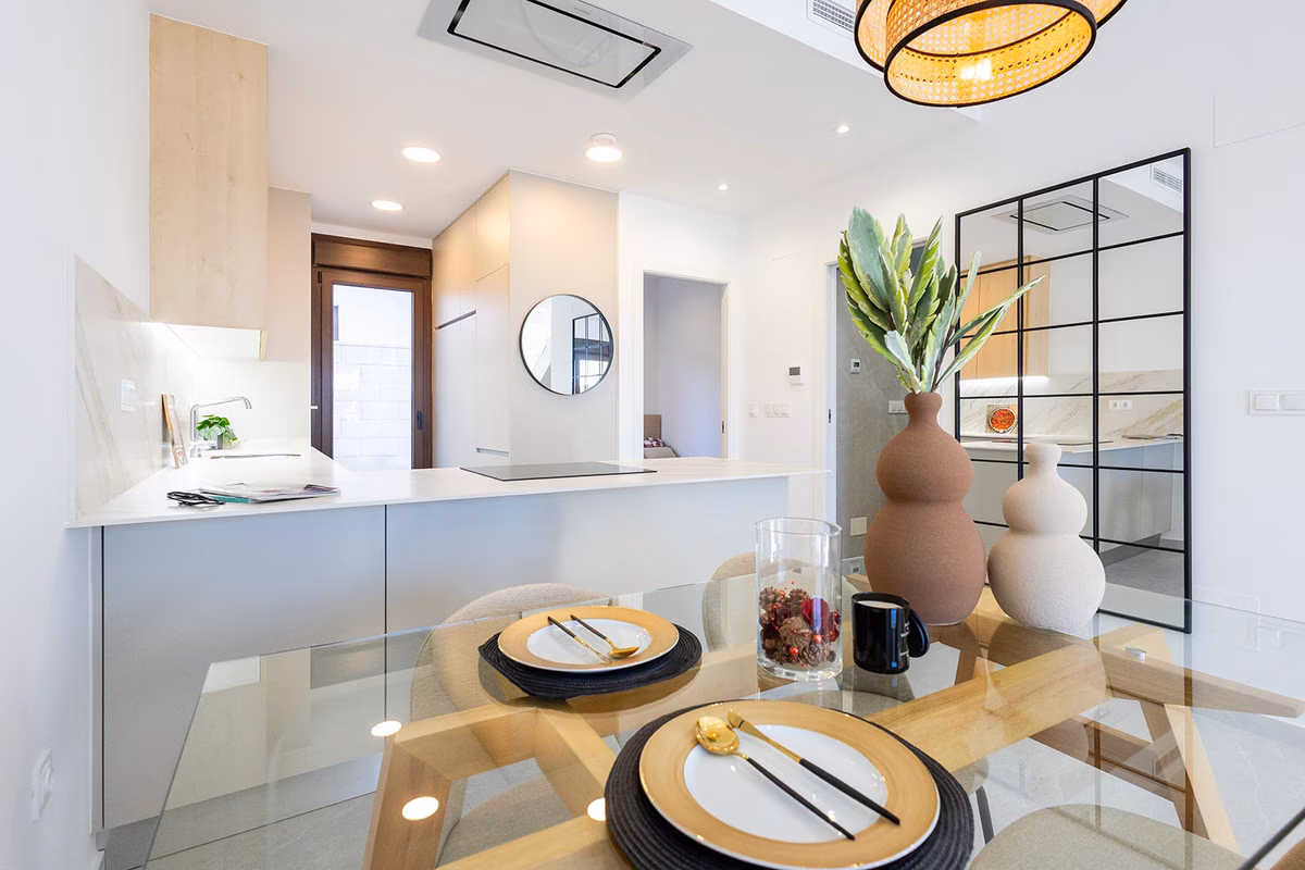 Glass dining table in front of the kitchen and a black-framed glazed partition