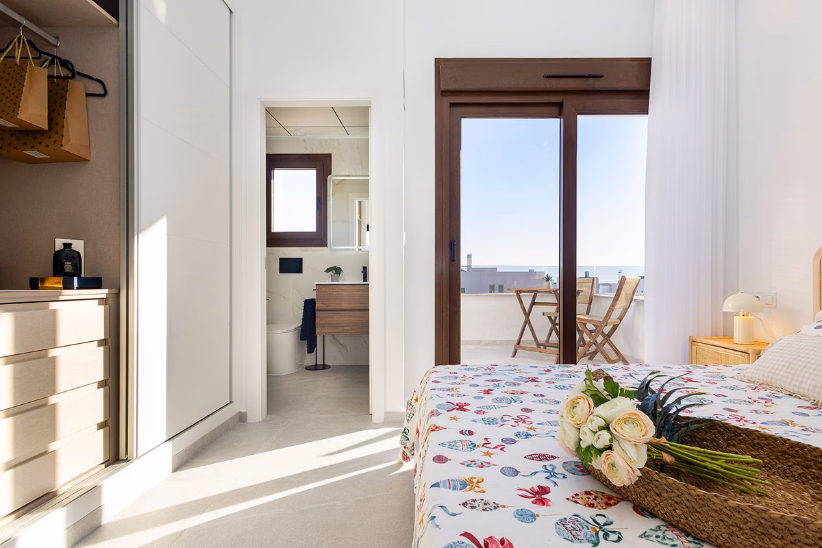 Upstairs bedroom with en-suite bathroom and glass doors to the terrace