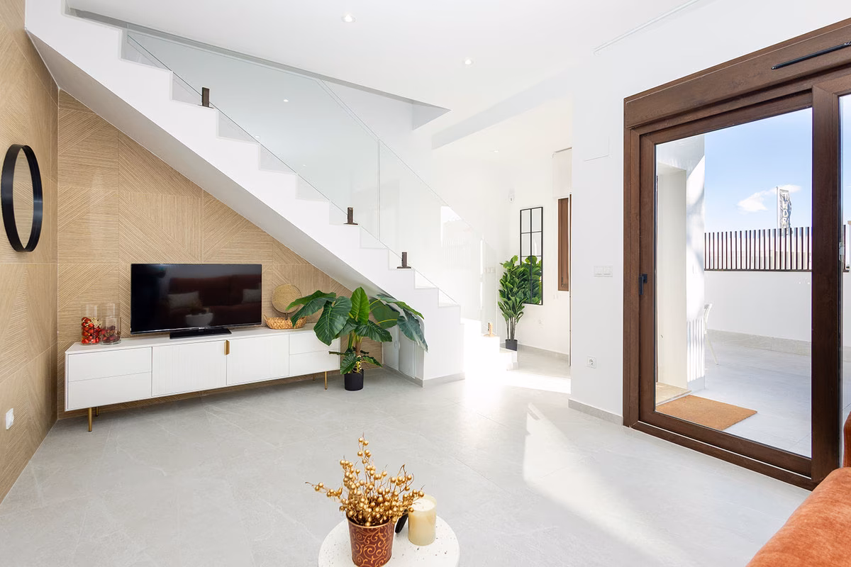 TV wall under the staircase and sliding door to the terrace