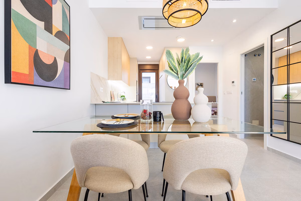 Dining table with upholstered chairs and the kitchen behind