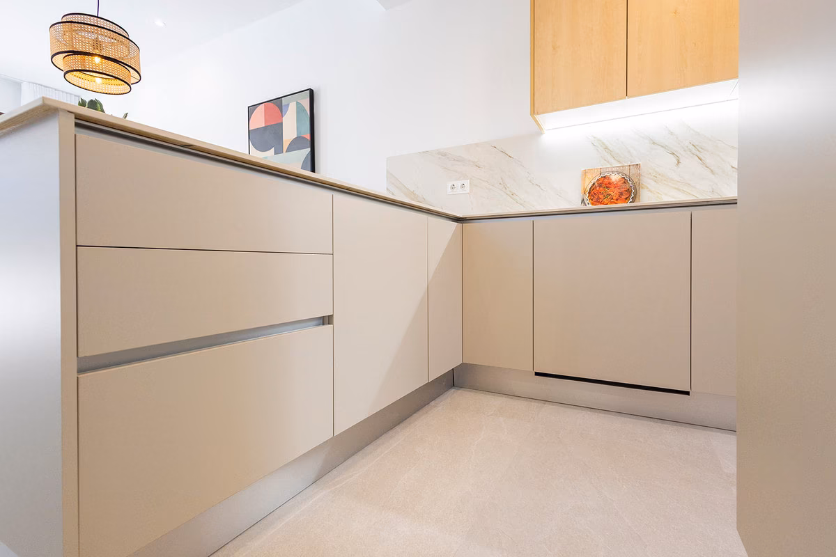 L-shaped kitchen with handleless beige units
