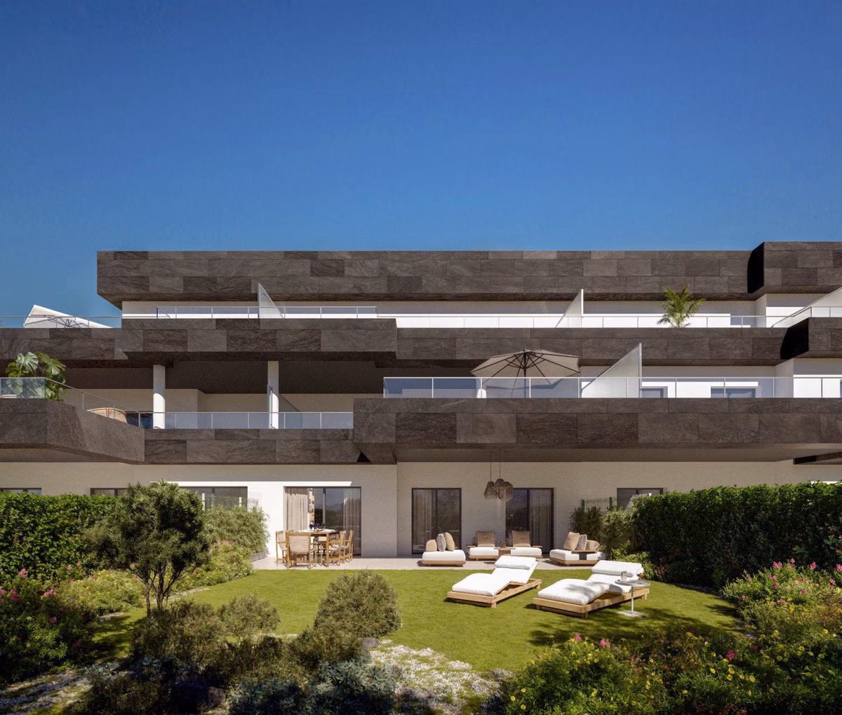 El edificio desde el jardín: césped y terraza de un bajo
