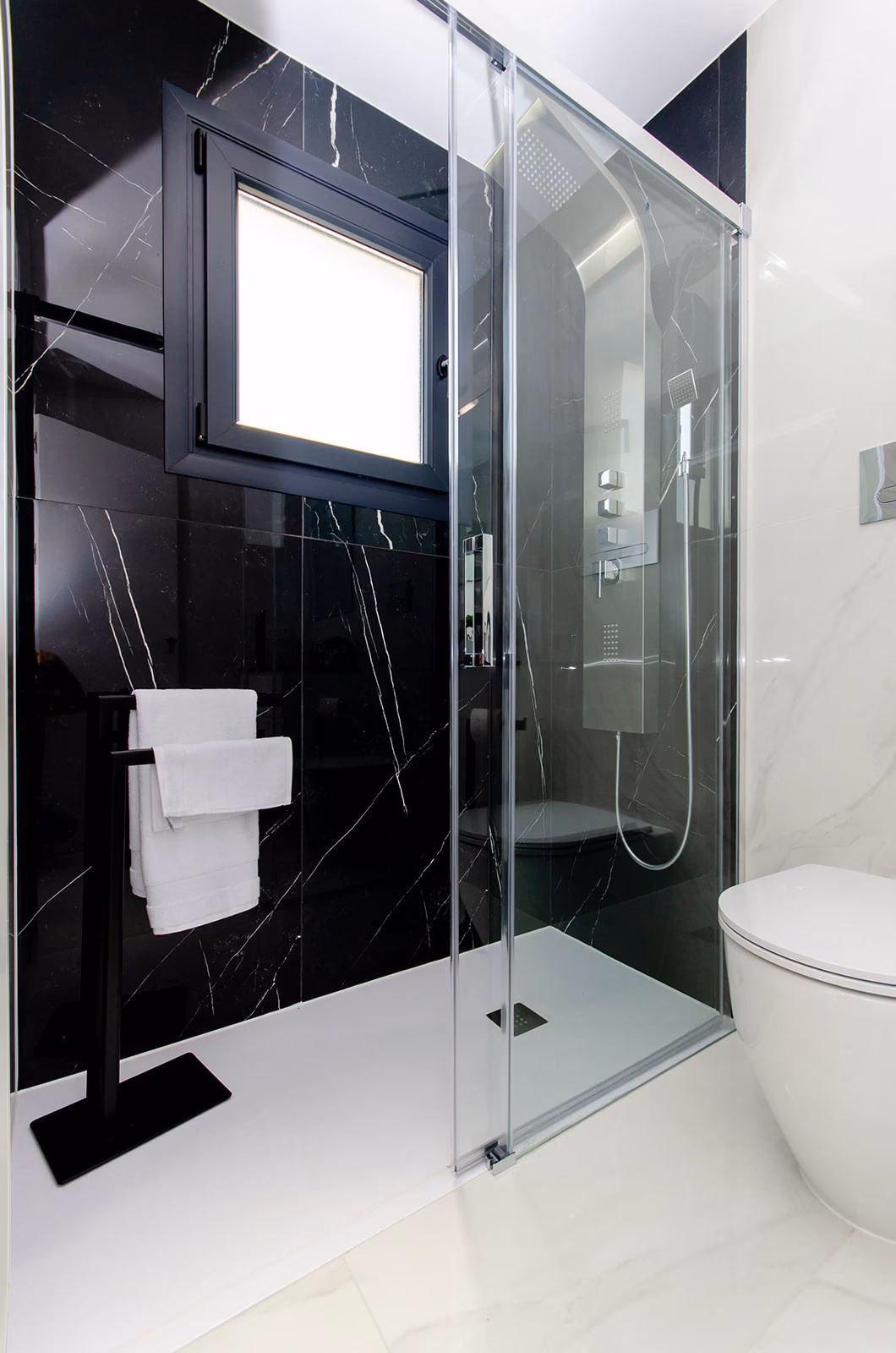 Bathroom with dark marble-effect walk-in shower