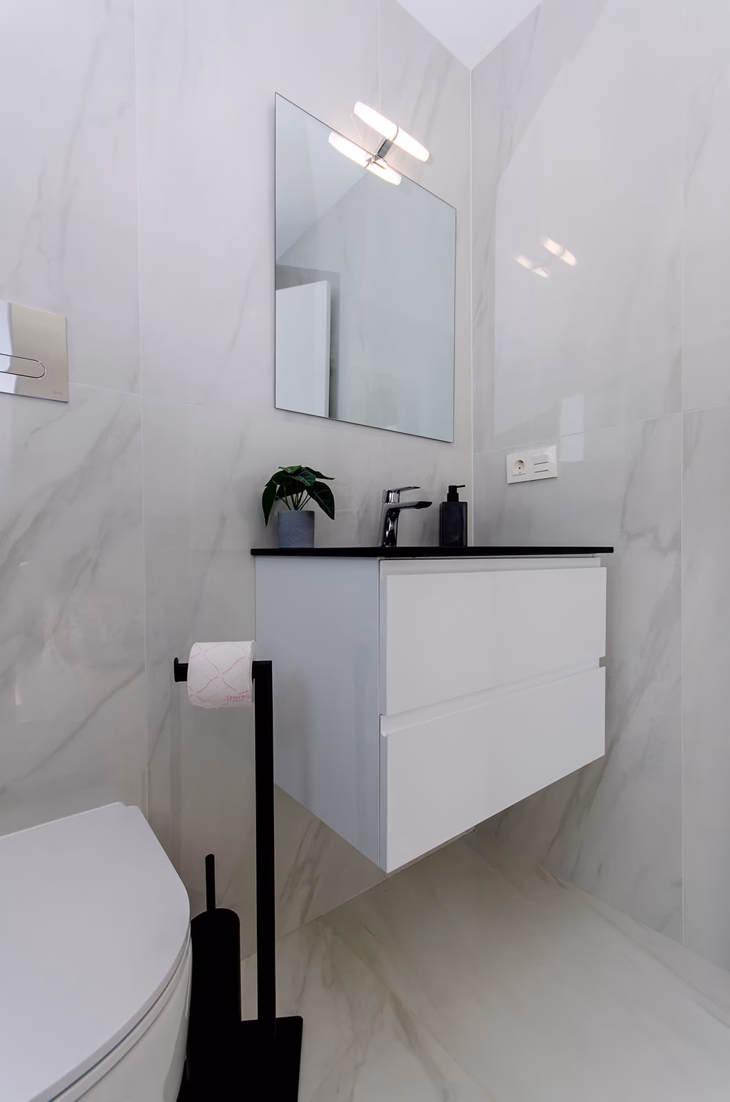 Bathroom with white vanity and illuminated mirror