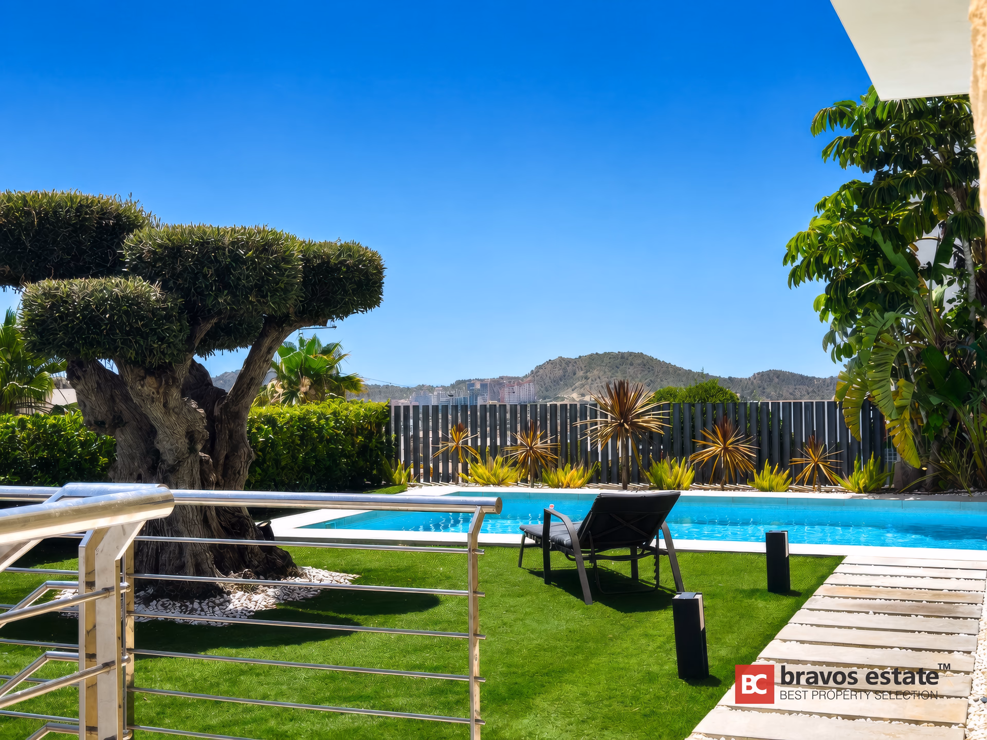 Piscine privée encadrée par le jardin avec vue sur la mer