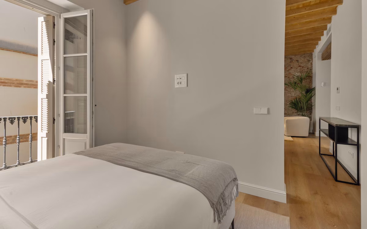 Schlafzimmer mit Fenstertür auf einen kleinen Balkon