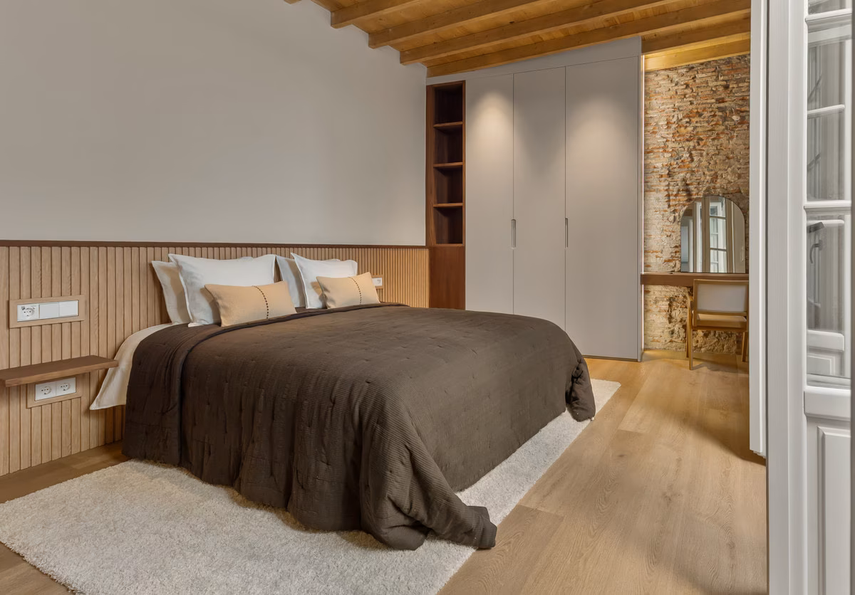 Schlafzimmer mit Einbauschrank und freiliegender Steinwand
